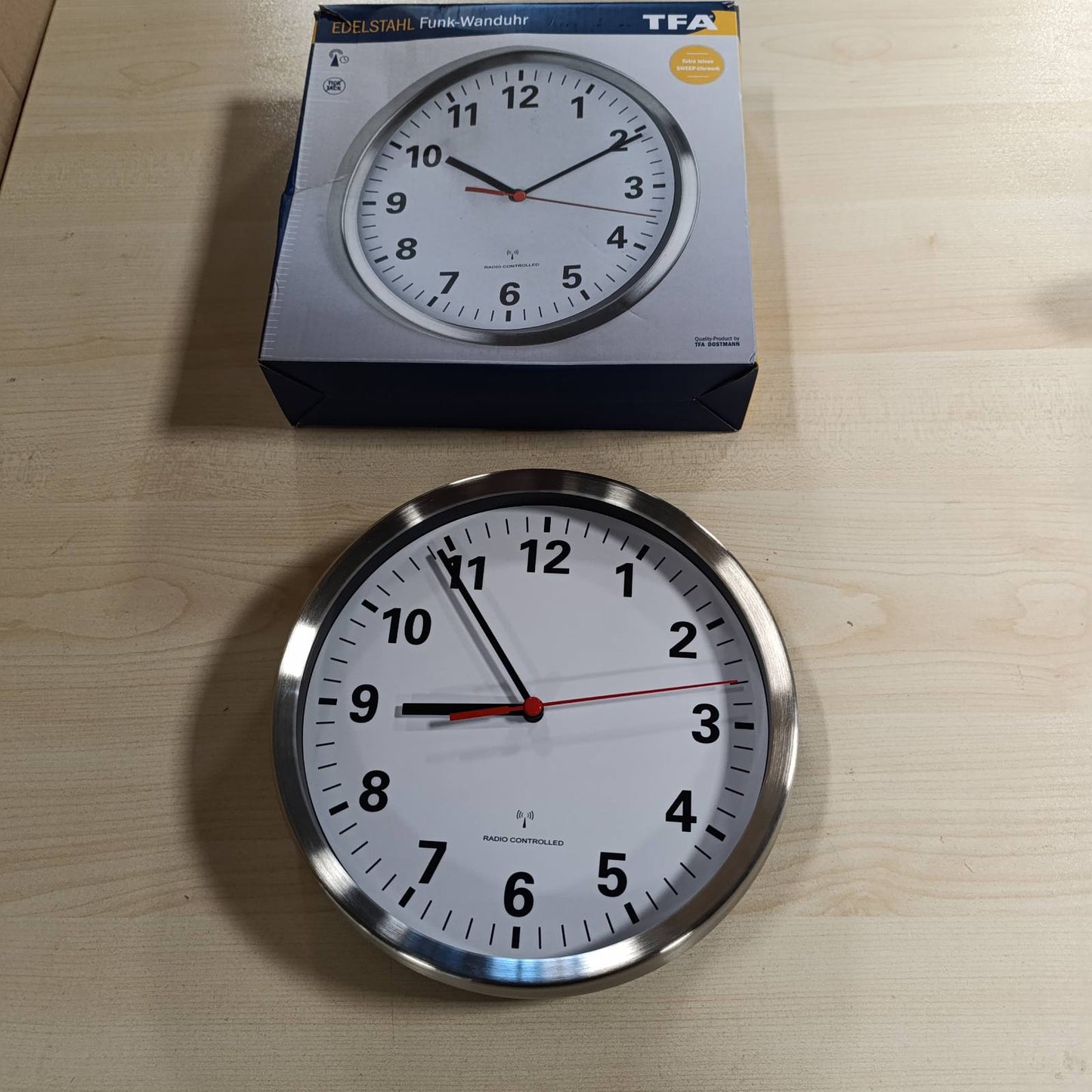 217896 - Orë muri analoge TFA Dostmann 60.3529.02, e heshtur, kornizë çeliku inox, diametër 22 cm, argjendi