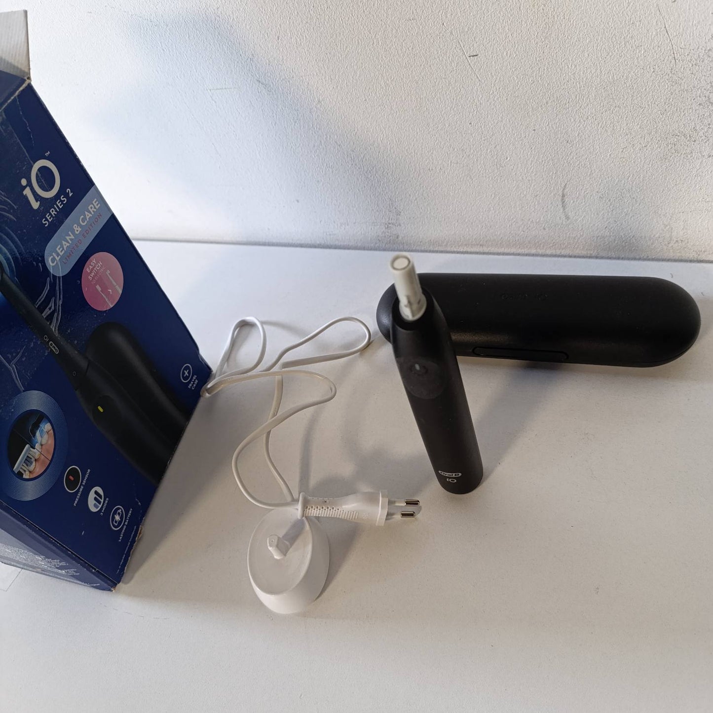 315488 - rçë dhëmbësh elektrike iO 2, 1 kokë zëvendësuese, 3 mënyra larjeje, sensor presioni, bateri rikarikueshme, çantë udhëtimi, e zezë