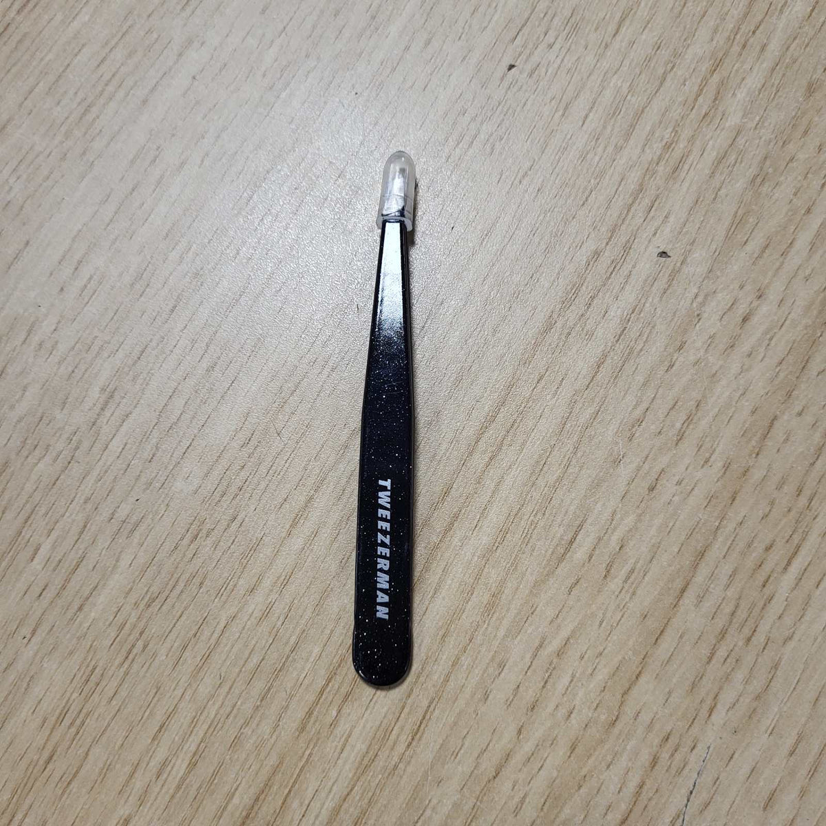 307802 - TWEEZERMAN Pincë e pjerrët për prerjen e vetullave, çelik inox, oniks i pluhurosur