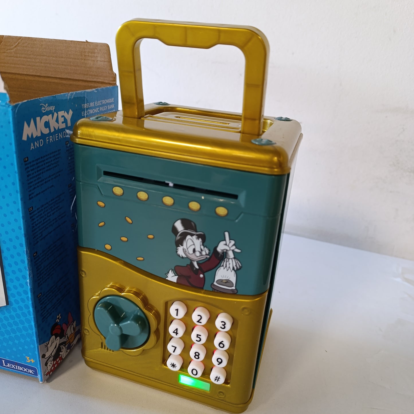 222013 - LEXIBOOK Kutia Elektronike e Parave Scrooge McDuck, Efektet e Zërit dhe Dritës, 9 Këngë, Jeshile/E Verdhë, JG150SC