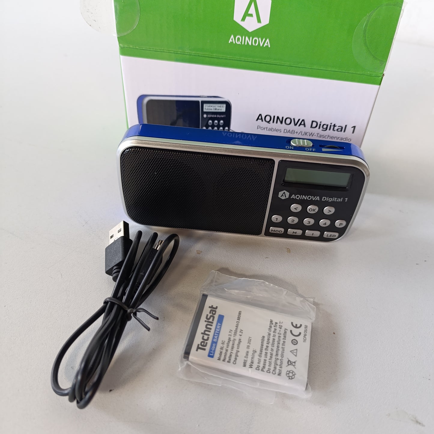268394 - AQINOVA - Digital 1, radio portative DAB+/FM (ekran LCD, memorie të preferuarave, butona të përzgjedhjes direkte, prizë për kufje, USB, hyrje AUX, elektrik dore LED, bateri e zëvendësueshme, 1 vat, e vogël) blu