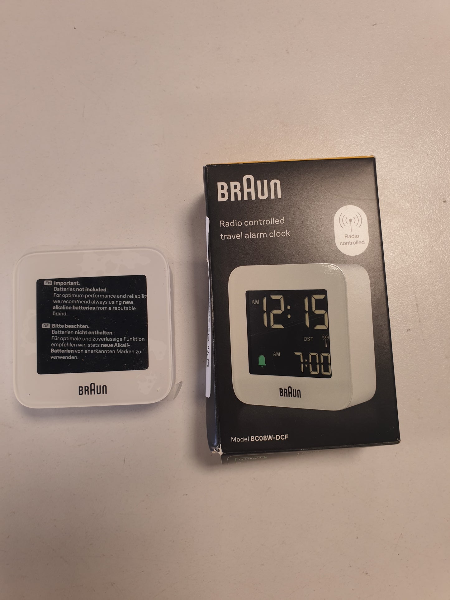 255700 - BRAUN - Orë dixhitale me alarm udhëtimi, Ora e Evropës Qendrore (CET), funksion shtyrjeje, madhësi kompakte, ekran LCD negativ, alarm Crescendo në të bardhë, modeli BC08W-DCF