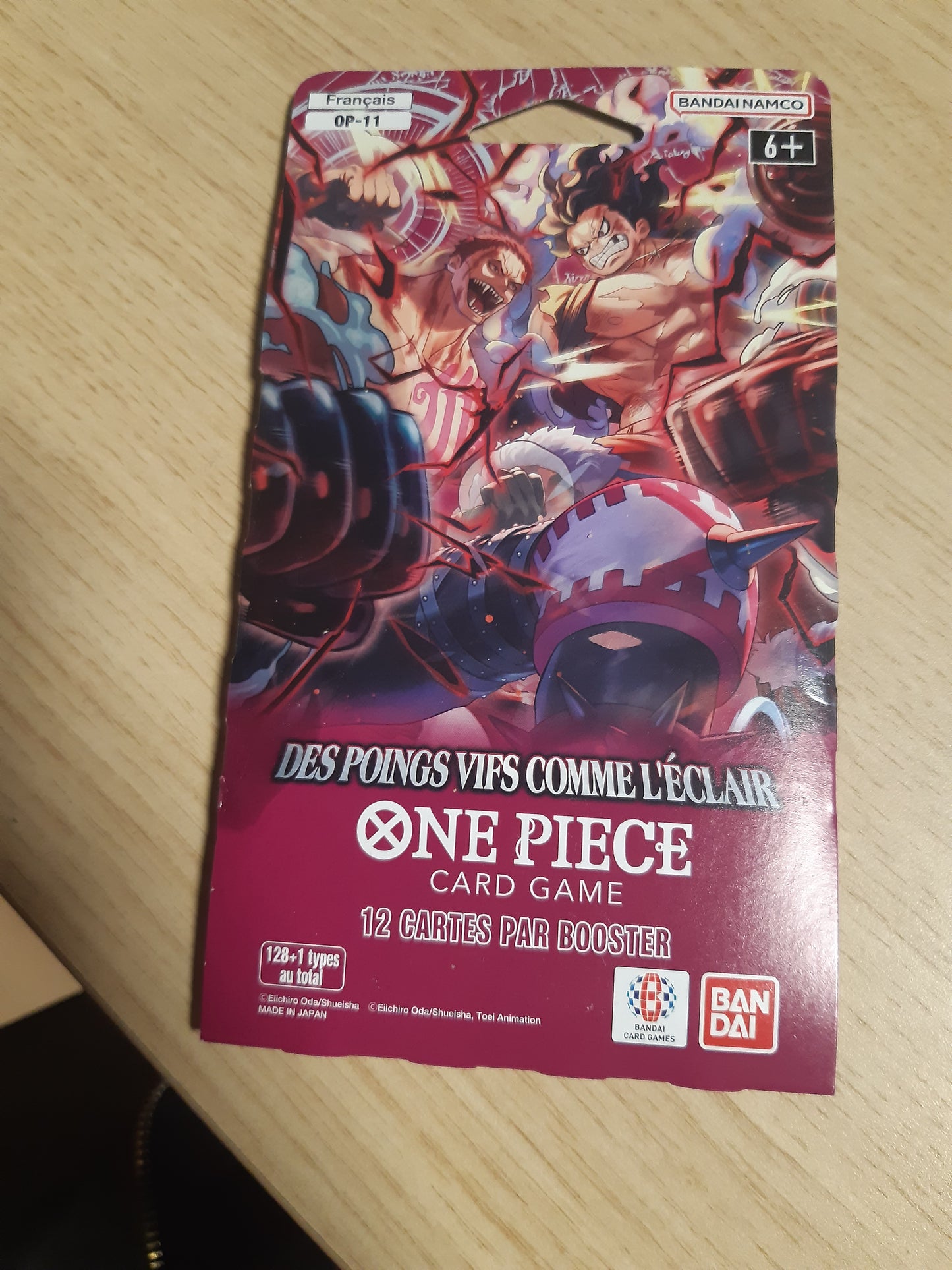 141693 - Asmodee - One Piece OP-11 Booster Blister - Bandai - “Grushta të shpejtë si rrufe” - lojë me letra koleksionuese - Whole Cake Island - “Një grusht me shpejtësi hyjnore” - version në gjuhën frënge.