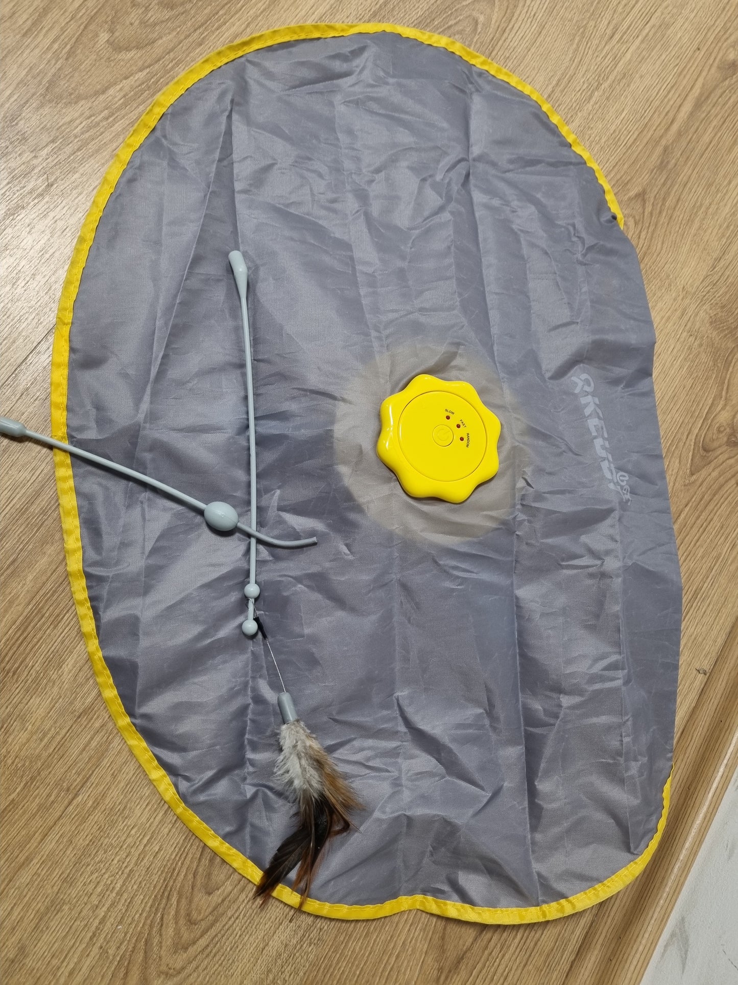 241249 - KERBL Lodër për mace 2 në 1 me kapak bishti, mustaqe pendësh, e verdhë, gri, 70x53x5cm, najlon, funksion fikjeje automatike, kundër rrëshqitjes