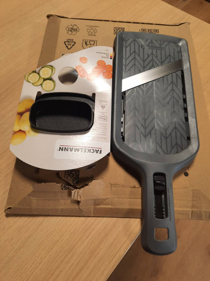 288467 - FACKELMANN MANDOLINË, prej çeliku inox me 4 nivele prerjeje, rrëshqitës ergonomik dhe mbajtëse skrapesh për prerje precize, prodhuar në Gjermani, ngjyrë gri