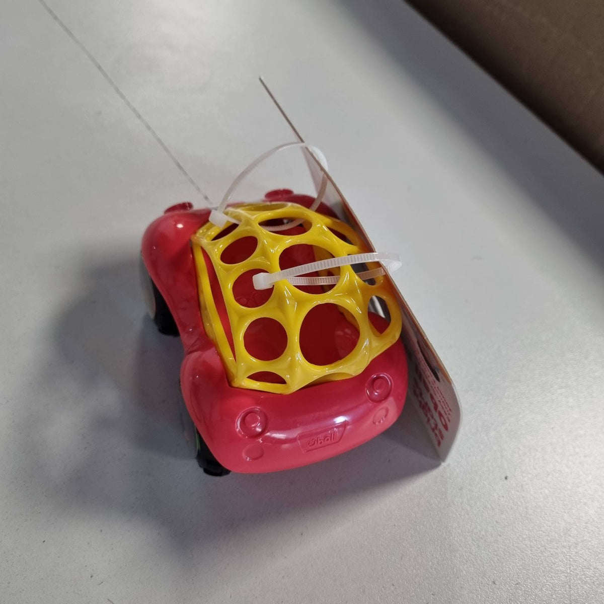 322031 - Bright Starts Starts, Oball, Makinë lodër me rrathë, Lodër aftësish motorike për foshnje dhe fëmijë të vegjël nga 3 muajsh, 1 copë, Ngjyrë e rastësishme blu ose e kuqe