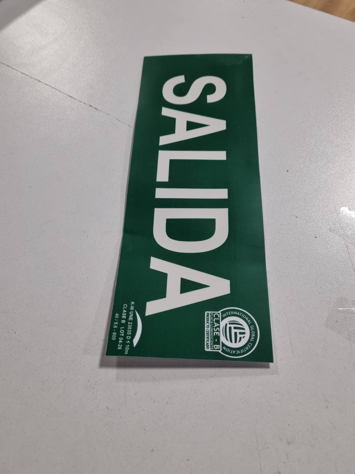 309399 - IBERNORMA SPB004 Prizë Evakuimi Sinjali 30x10.5cm Klasa BD≤7m Lumineshente PVC e Miratuar UNE 23034:2023 (Klasa B)