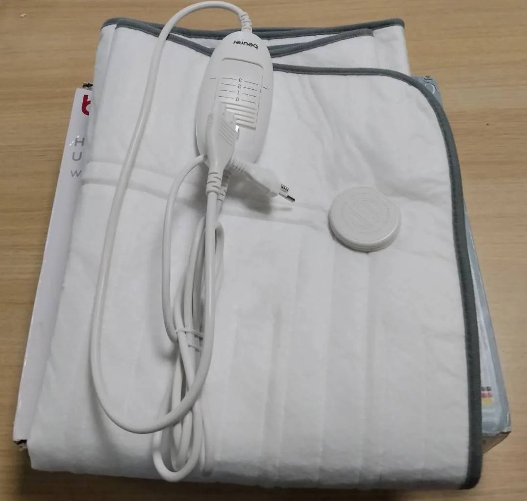 318714 - Dyshek elektrik Beurer TS 17, material i butë prej pelushi (fleece), që nuk rrëshqet falë fiksimit me shirit elastik, 3 nivele temperature, 150x80 cm, sistem sigurie, çelës i heqshëm, lahet në lavatriçe në 30°C, ngjyrë gri.