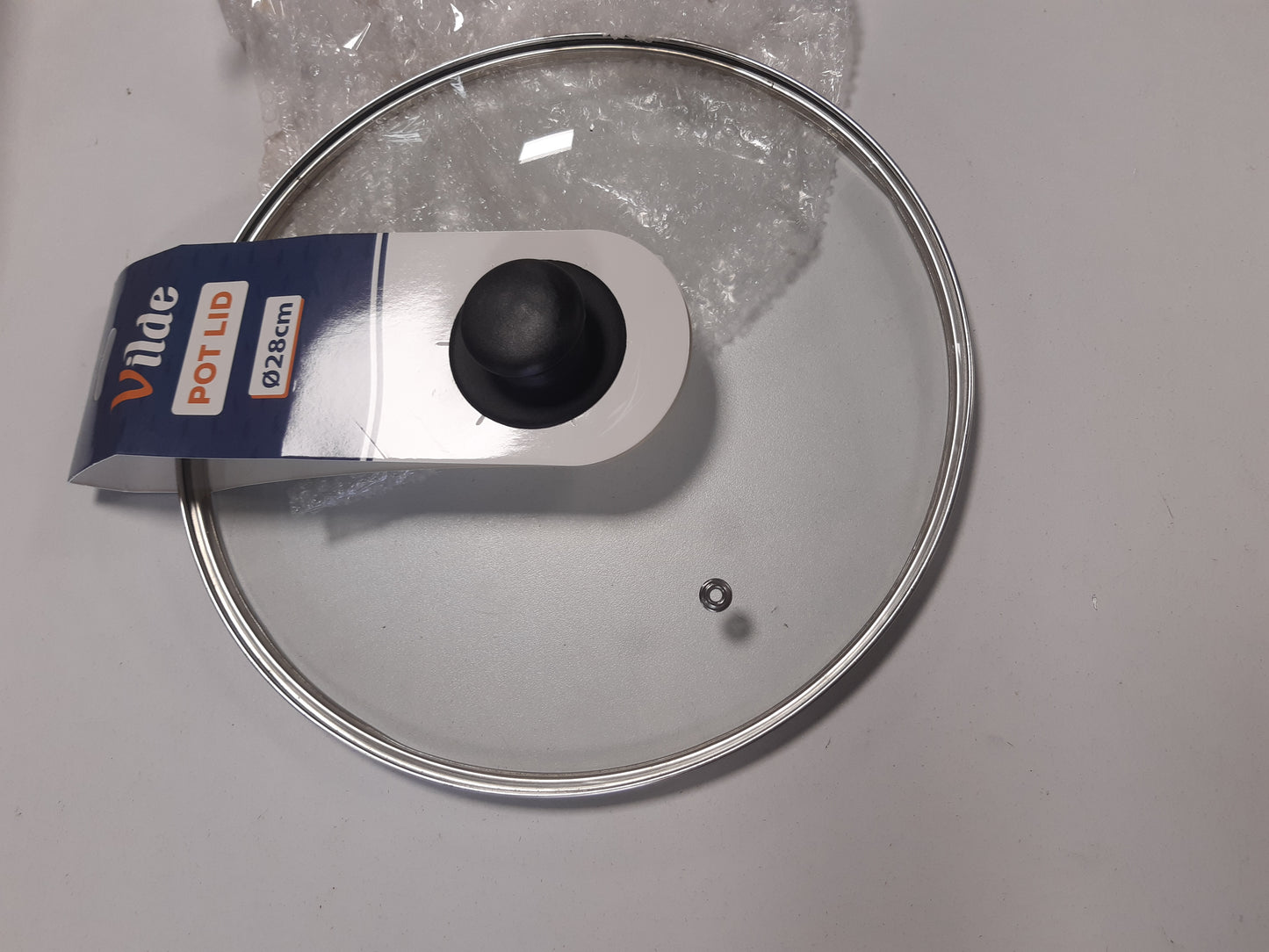 254325 - VILDE Kapak qelqi universal 28 cm - Rezistent ndaj nxehtësisë deri në 200°C - Rrip çeliku inox në ngjyrë argjendi dhe dorezë plastike - Për tenxhere, tiganë dhe tava - Me kanal avulli - Sistem transparent shikimi