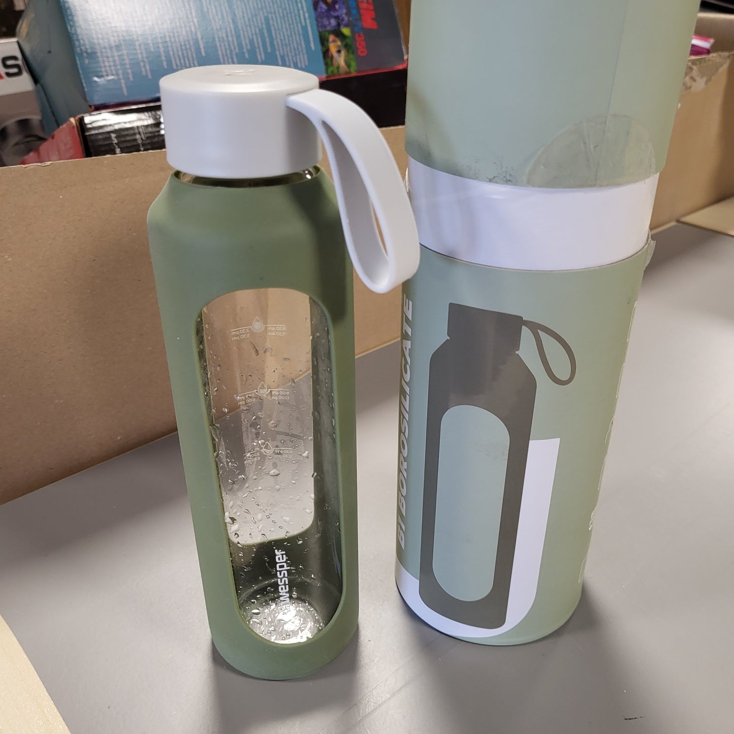 263339 - WESSPER Shishe Uji prej Qelqi 500 ml, me shkallë hidratimi, borosilikat me mbështjellëse silikoni, pa BPA, ngjyrë ulliri