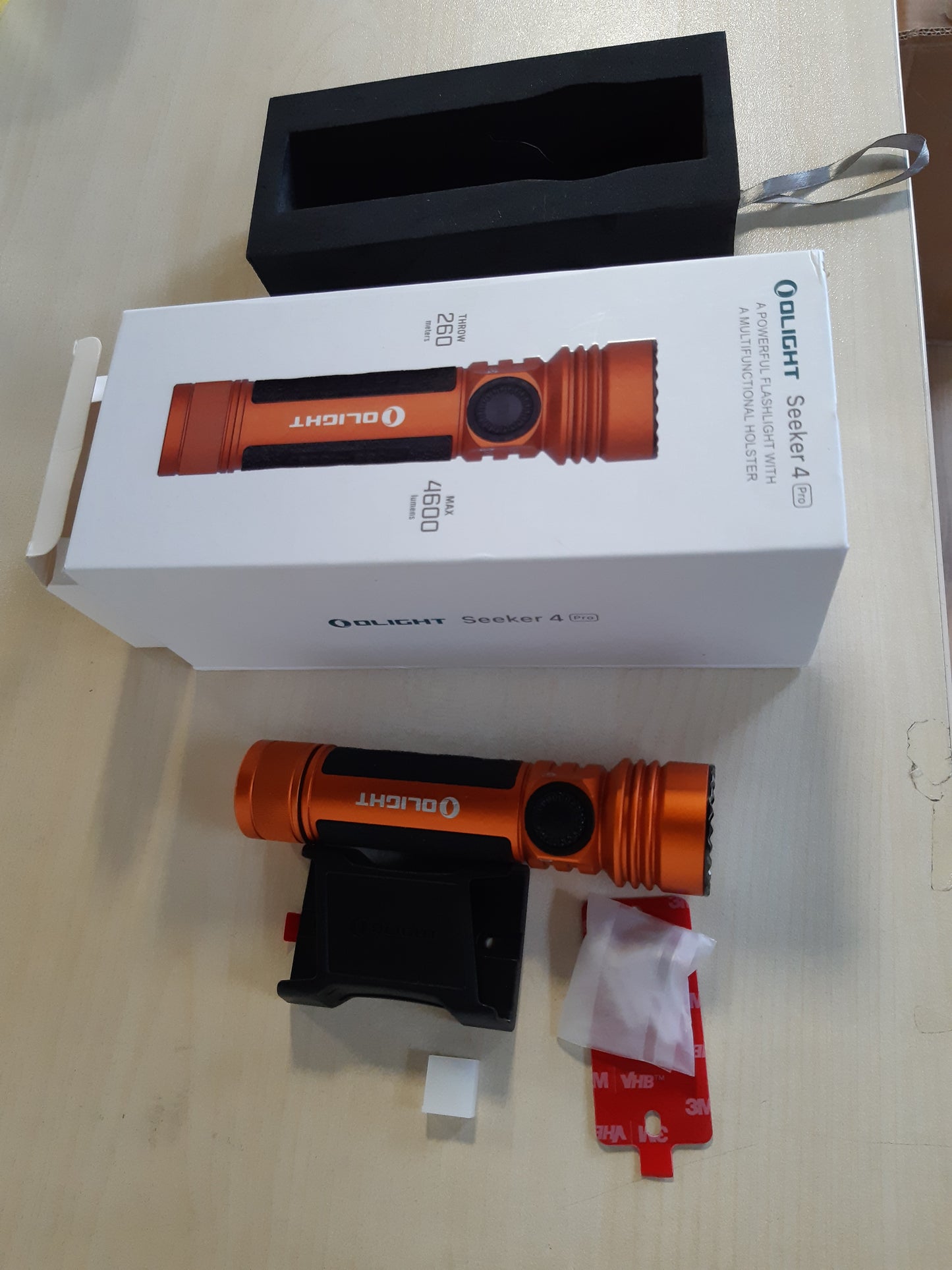 153048 - OLIGHT Seeker 4 Pro - Dritë Dore LED e Rikarikueshme, 4600 Lumen, me Mbajtëse Automatike, Opsione Karikimi për Kamping dhe Emergjenca, Ngjyrë Portokalli