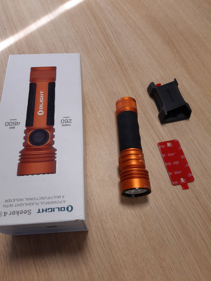 153048 - OLIGHT Seeker 4 Pro - Dritë Dore LED e Rikarikueshme, 4600 Lumen, me Mbajtëse Automatike, Opsione Karikimi për Kamping dhe Emergjenca, Ngjyrë Portokalli