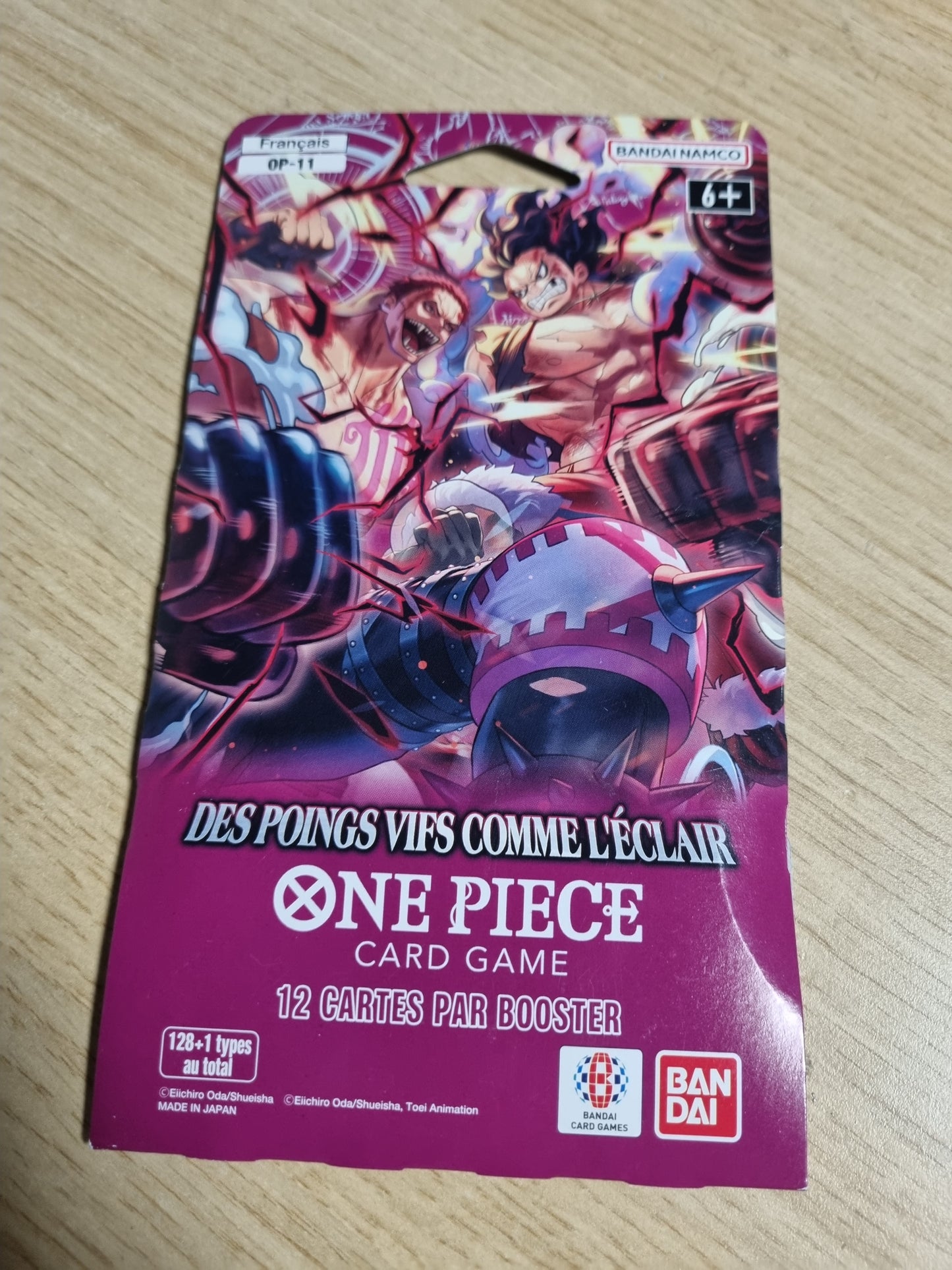 141694 - Asmodee – Bandai One Piece OP-11 Booster Blister – “Grushta të shpejtë si rrufe” – lojë me letra koleksionuese – Whole Cake Island – “Grusht me shpejtësi hyjnore” – version në gjuhën frënge.